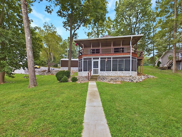 back of property with a sunroom and a yard