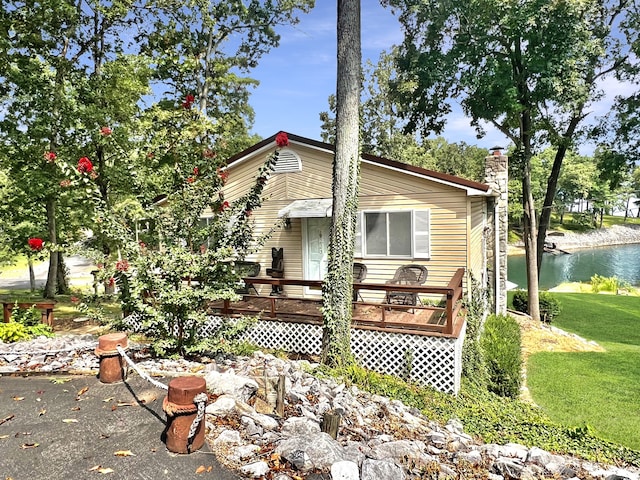 back of property with a lawn and a deck