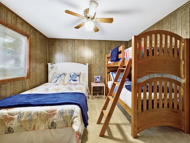 bedroom with carpet flooring, wooden walls, and ceiling fan