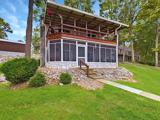 rear view of property featuring a yard and a sunroom