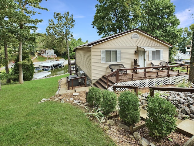 back of house with a wooden deck and a lawn