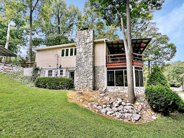 back of house with a lawn and a sunroom