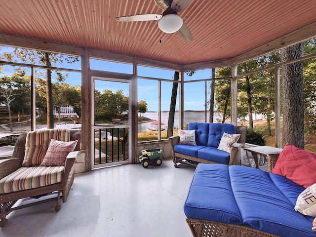 sunroom / solarium with a water view and ceiling fan