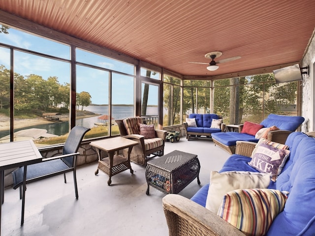 sunroom / solarium with a water view and ceiling fan