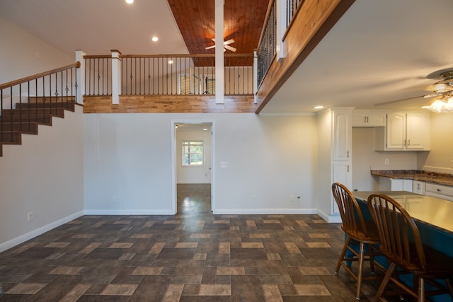 dining area with ceiling fan, lofted ceiling, and bar