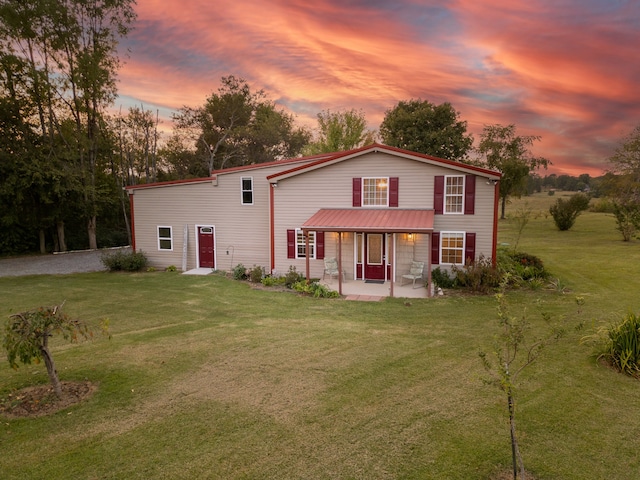 back house at dusk with a lawn