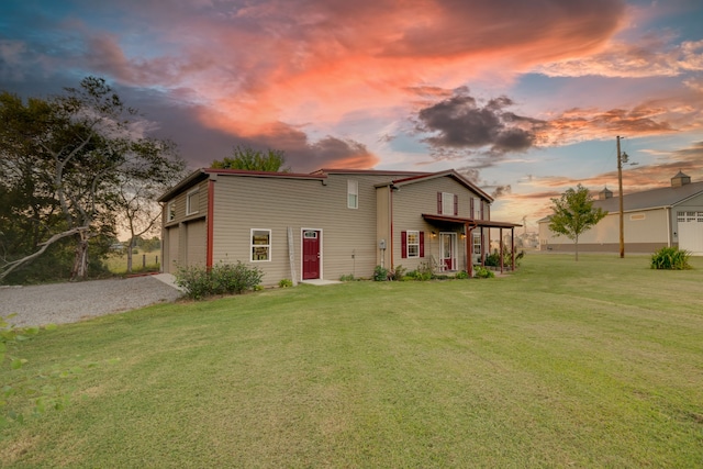 back house at dusk with a yard and a garage