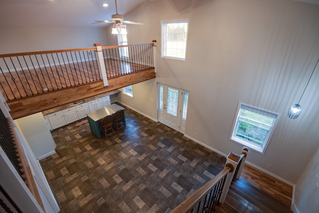 stairs with vaulted ceiling, ceiling fan, and hardwood / wood-style flooring