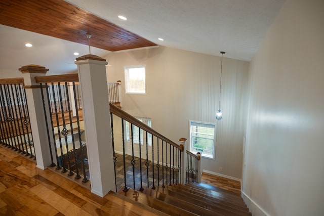 stairway featuring hardwood / wood-style flooring and lofted ceiling