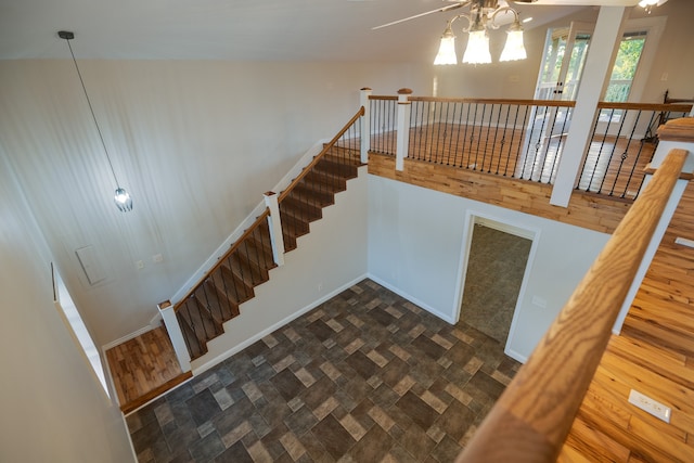 stairway with a notable chandelier and wood-type flooring