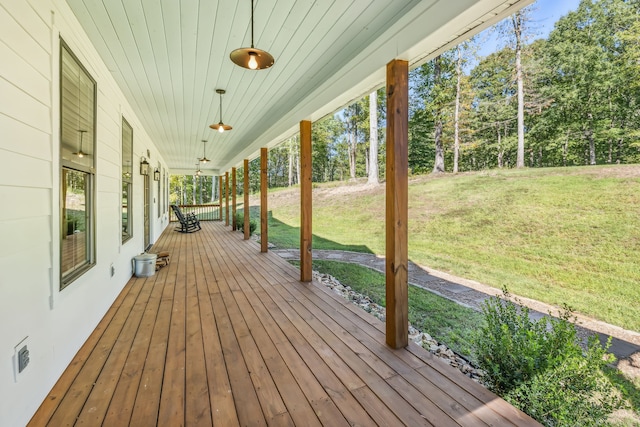 wooden terrace with a lawn and covered porch