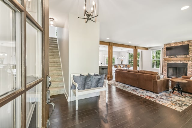 living room featuring a chandelier, a fireplace, and dark hardwood / wood-style flooring