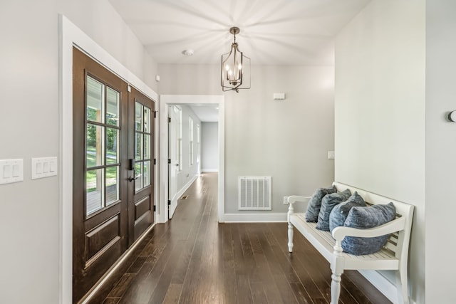 doorway to outside with an inviting chandelier, dark wood-type flooring, and french doors