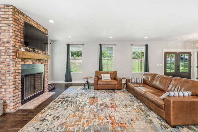 living room with a brick fireplace, french doors, and dark hardwood / wood-style flooring