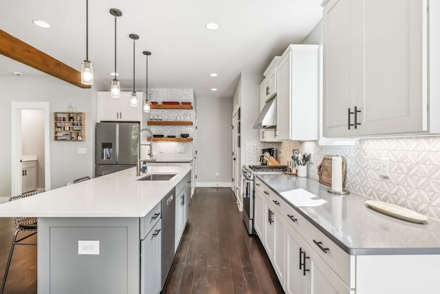 kitchen with stainless steel appliances, white cabinetry, and a kitchen island with sink