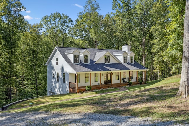 cape cod home with a front lawn and covered porch