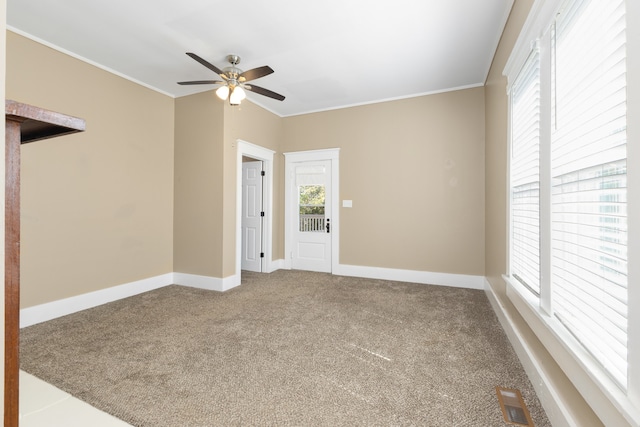 carpeted spare room featuring ceiling fan and ornamental molding