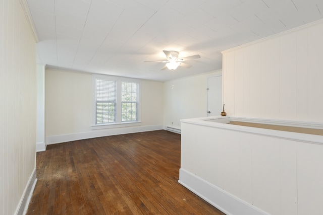 unfurnished room with ceiling fan, crown molding, dark hardwood / wood-style flooring, and a baseboard heating unit