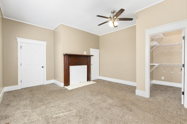 unfurnished living room with crown molding, carpet flooring, and ceiling fan