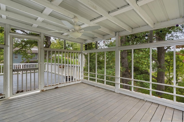 unfurnished sunroom featuring ceiling fan and beam ceiling