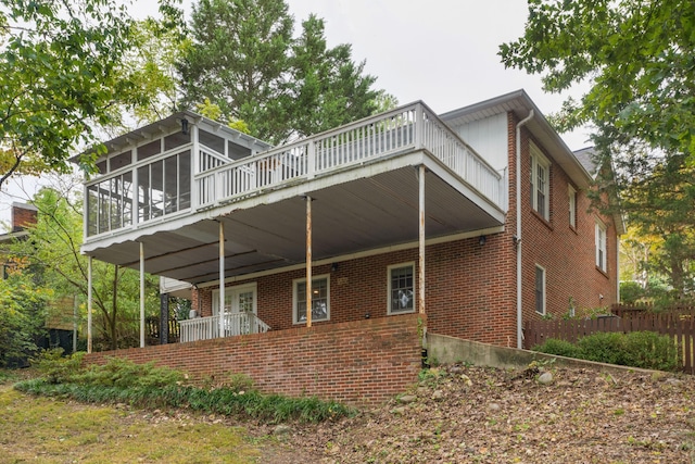 back of property with a sunroom and a deck