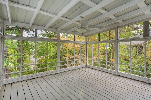 unfurnished sunroom featuring ceiling fan and beamed ceiling