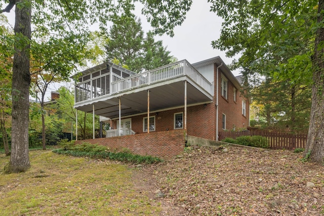 back of property with a wooden deck and a sunroom