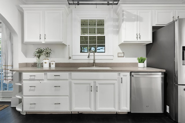 kitchen with appliances with stainless steel finishes, sink, dark hardwood / wood-style floors, and white cabinets