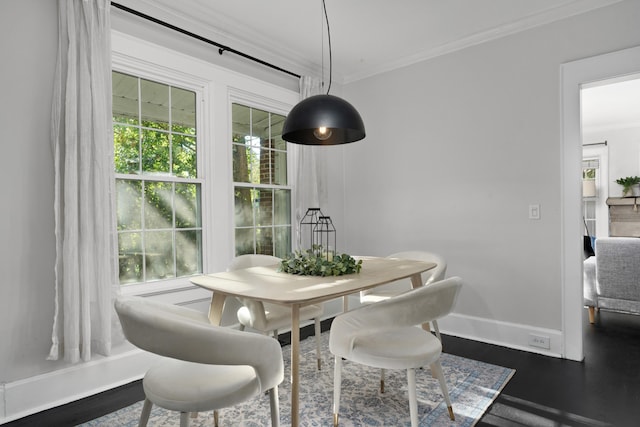 dining area with ornamental molding and dark hardwood / wood-style floors