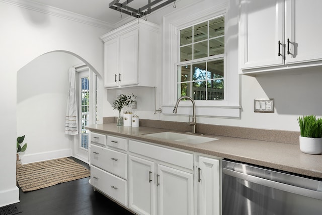 kitchen with white cabinets, dark hardwood / wood-style flooring, stainless steel dishwasher, crown molding, and sink