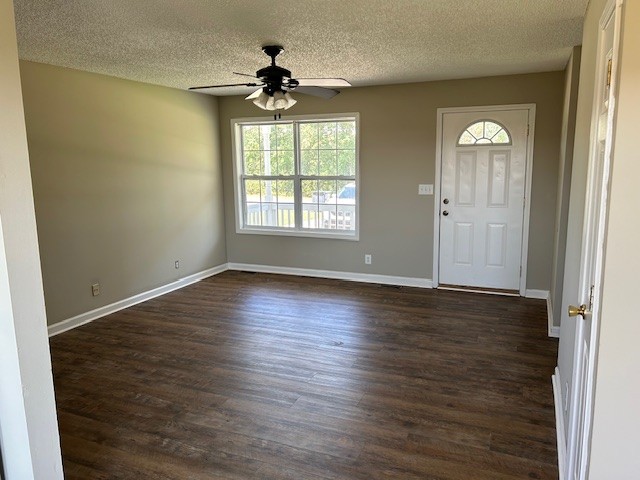 entryway featuring ceiling fan, dark wood-type flooring, and a textured ceiling