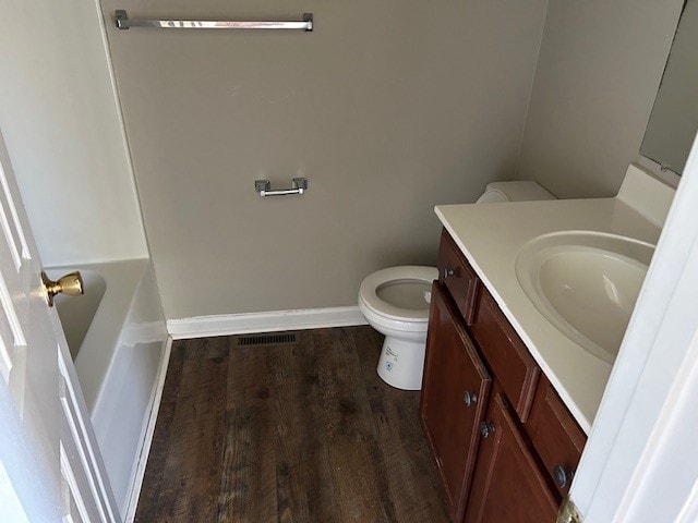 bathroom with hardwood / wood-style floors, vanity, and toilet