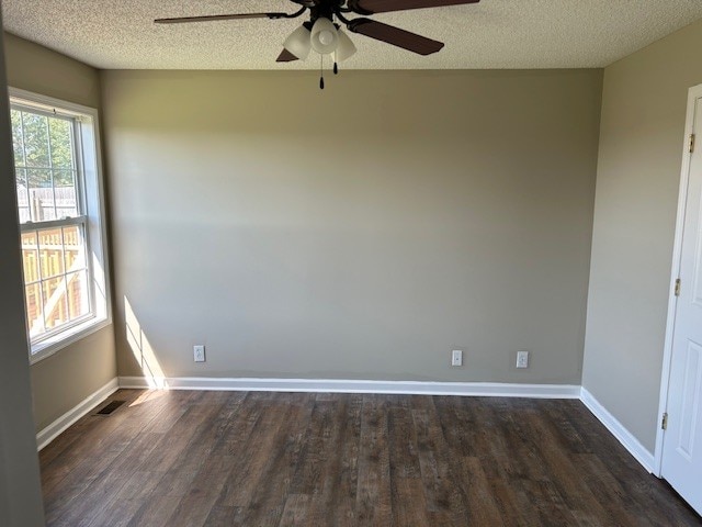 unfurnished room with a textured ceiling, dark wood-type flooring, and ceiling fan