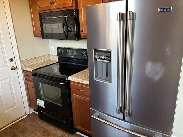 kitchen featuring black appliances and dark hardwood / wood-style floors