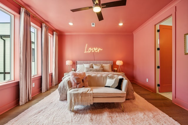 bedroom featuring ceiling fan, ornamental molding, and wood-type flooring