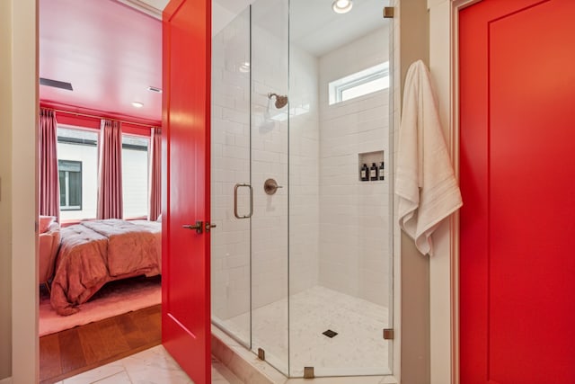 bathroom with hardwood / wood-style floors and a shower with shower door