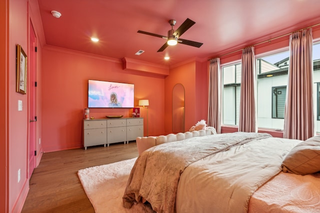 bedroom featuring ceiling fan, light hardwood / wood-style floors, and crown molding