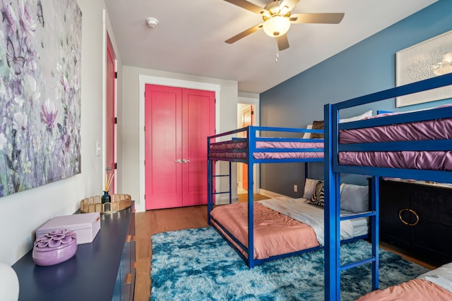 bedroom with dark hardwood / wood-style floors, ceiling fan, and a closet