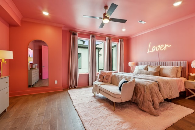 bedroom with ornamental molding, hardwood / wood-style floors, and ceiling fan