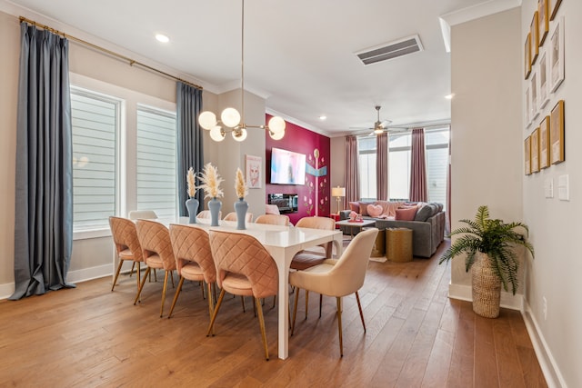 dining room with hardwood / wood-style flooring, ceiling fan, and crown molding