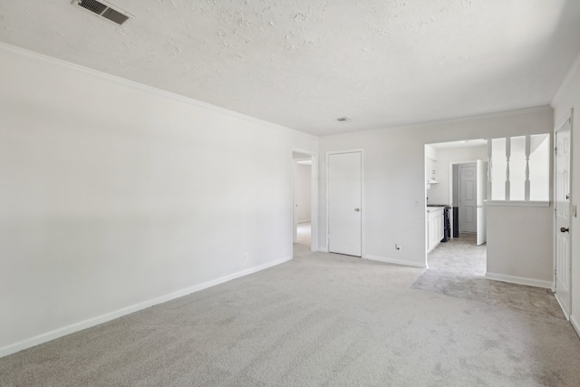 unfurnished room featuring light carpet, a textured ceiling, and ornamental molding