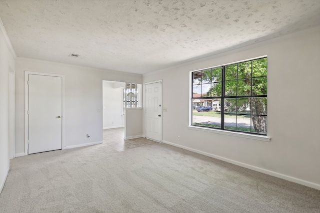 carpeted empty room with a textured ceiling and ornamental molding