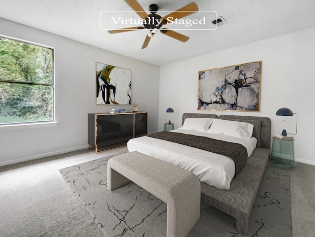 bedroom with a textured ceiling, carpet flooring, and ceiling fan