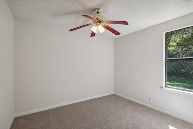 spare room with a textured ceiling, carpet flooring, and ceiling fan