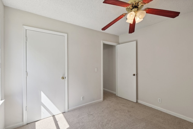 unfurnished bedroom with light carpet, a closet, ceiling fan, and a textured ceiling