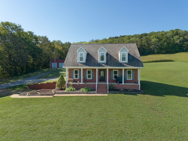 cape cod house featuring a front lawn and covered porch