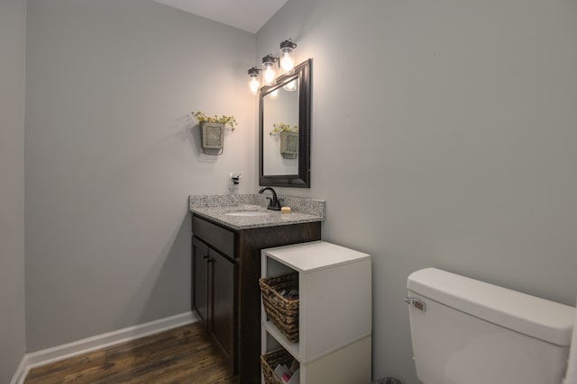 bathroom with hardwood / wood-style floors, vanity, and toilet