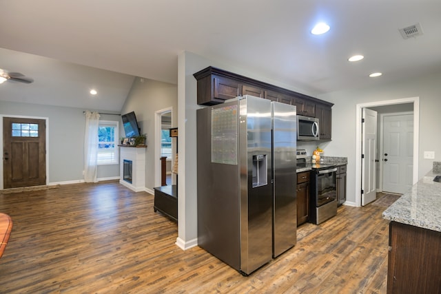 kitchen featuring dark brown cabinets, stainless steel appliances, dark hardwood / wood-style floors, and lofted ceiling