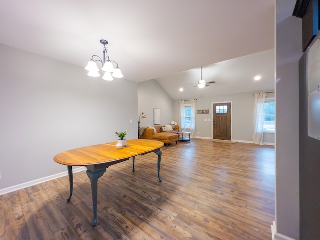 dining area featuring ceiling fan with notable chandelier, lofted ceiling, and dark hardwood / wood-style flooring