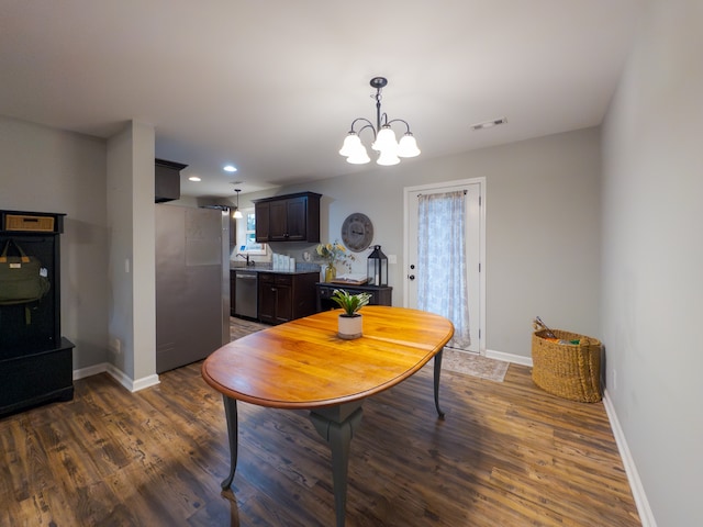 dining room featuring an inviting chandelier, sink, and dark wood-type flooring